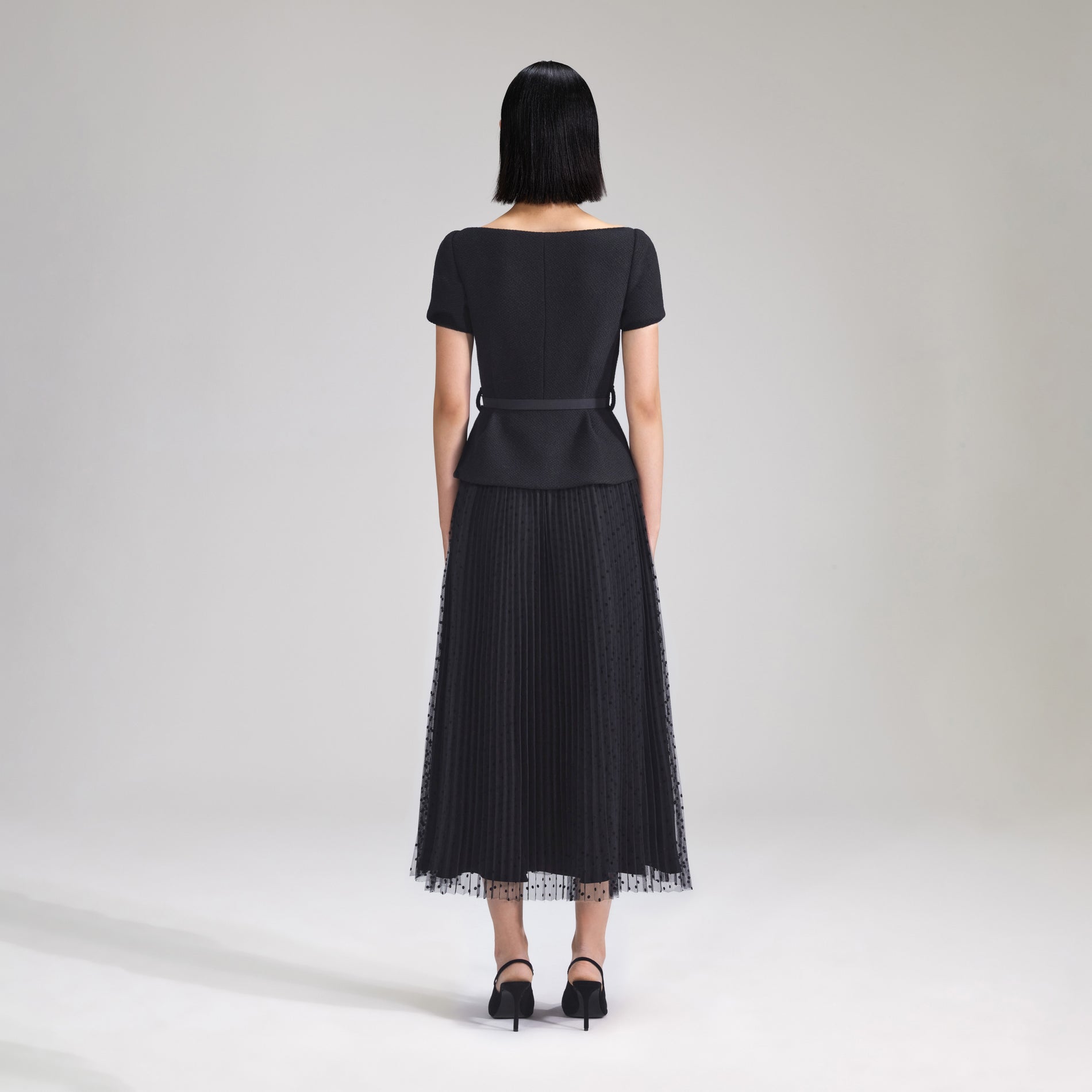 A woman wearing the Black Off Shoulder Midi Dress