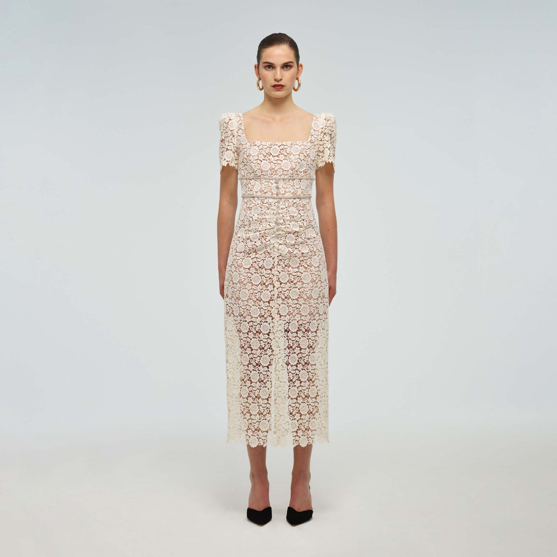 A woman wearing the Ivory Guipure Fitted Midi Dress