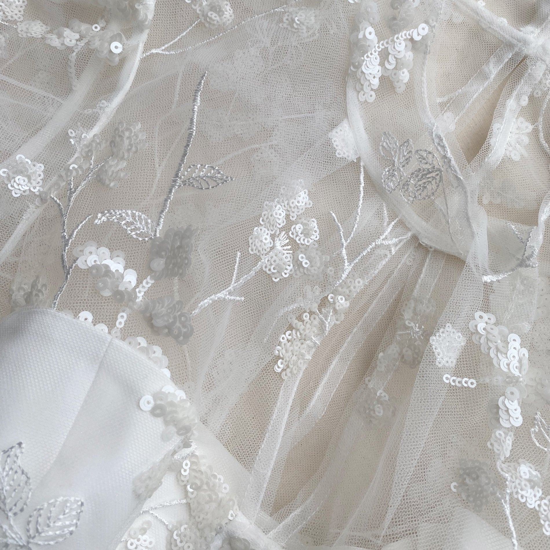 A close up of the fabric for the Ivory Blossom Sequin Tiered Maxi Dress